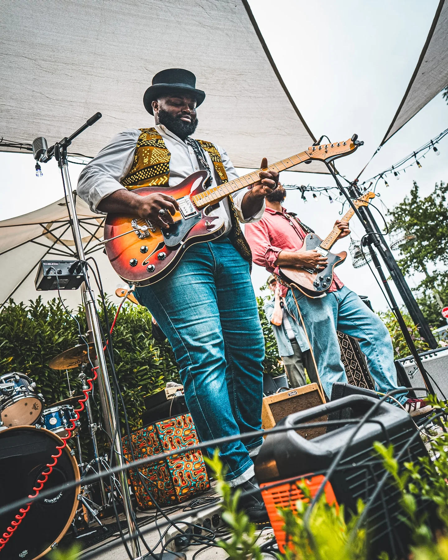 Cuppa T Jones and a bandmate playing electric guitars together onstage.