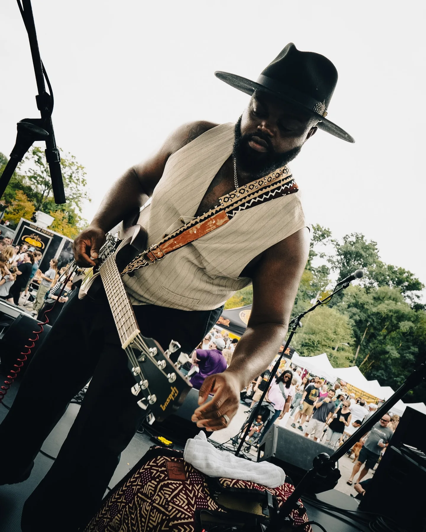 Cuppa T Jones leaning into his guitar during an outdoor performance.