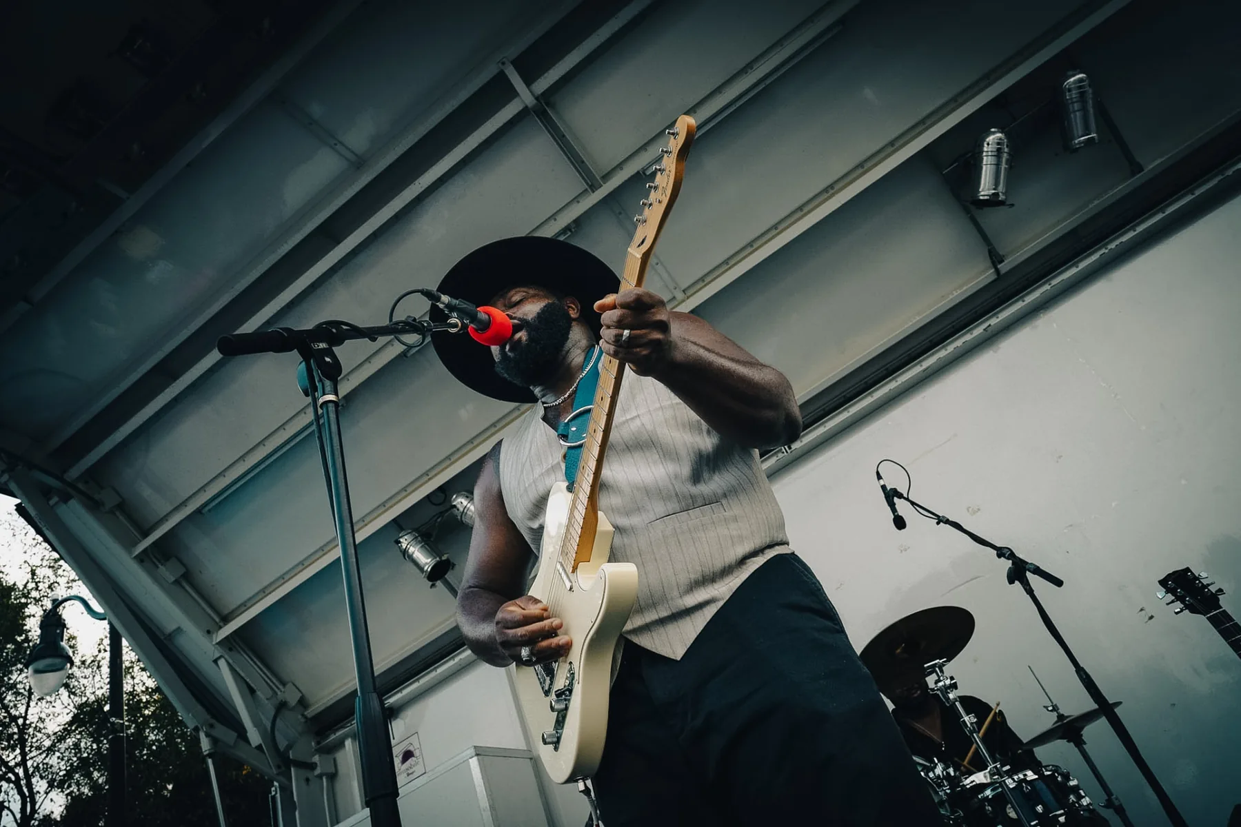 Cuppa T Jones singing and playing guitar during a live performance.